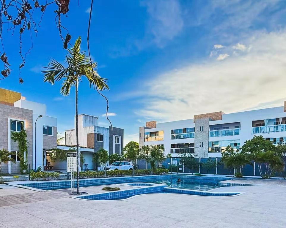 a building with a palm tree in front of it at Casa condominio Carpe Diem in Marechal Deodoro
