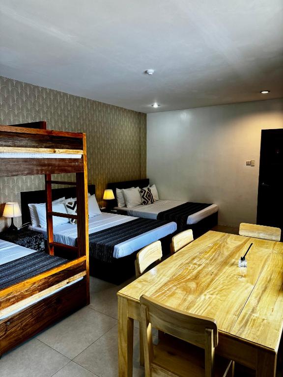 a room with two beds and a table and a dining room at Lakambini Transient in El Nido