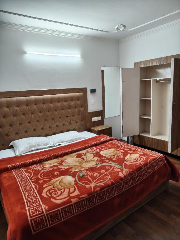 a bedroom with a bed with a red blanket on it at Hotel Premier in Manāli