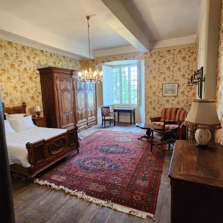 a bedroom with a bed and a table and a rug at Château de Trévien in Trévien