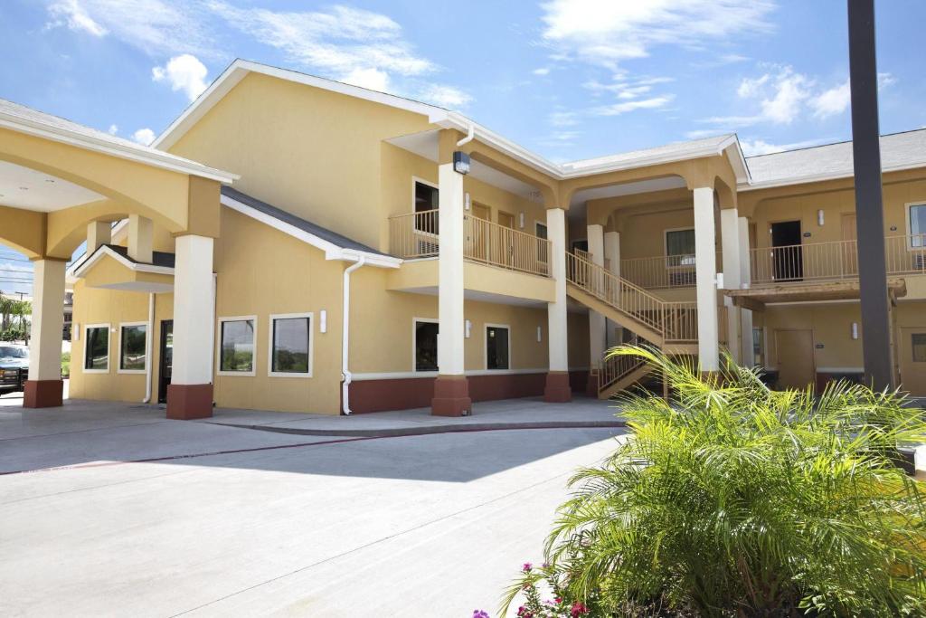 a large apartment building with a parking lot at Days Inn & Suites by Wyndham Gonzales TX in Gonzales