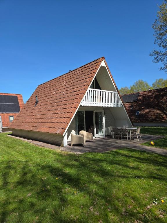a large house with a roof with a patio at Groene Specht 16 in Gramsbergen