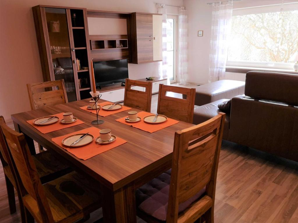 a kitchen and dining room with a wooden table at Appartment Schlossblick in Wiesenthau