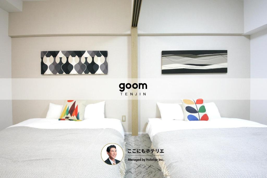 two beds in a room with a picture of a man at goom Hotel Fukuoka-Tenjin in Fukuoka