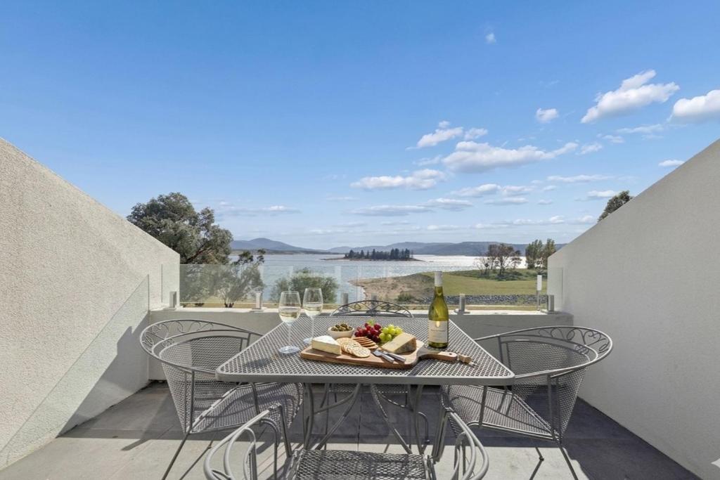 a table with a plate of food and a bottle of wine at Horizons 302 in Jindabyne