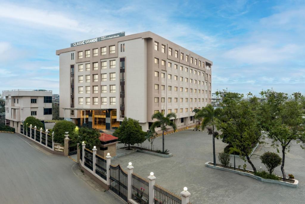 a large white building with a fence in front of it at Classic Grande,a Member of Radisson in Imphal