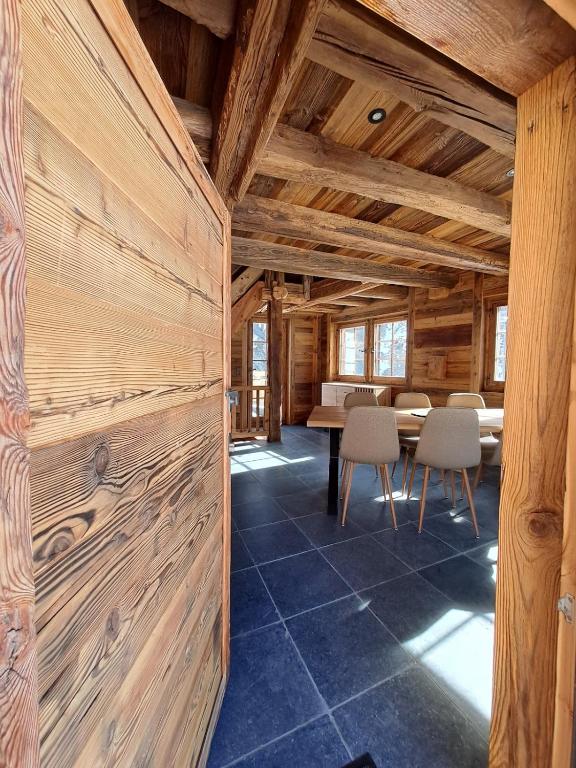a room with wooden walls and a table and chairs at Chalet La Grange à Philippe in Evolène