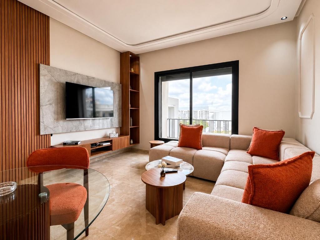 a living room with a couch and a tv at Oasis Hills - Modern & Cosy 1BR with Balcony - Central in Casablanca