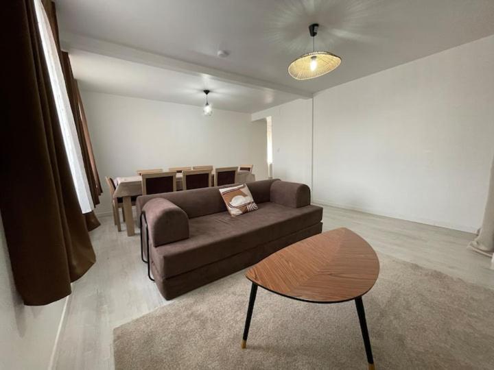 a living room with a couch and a table at Maison 3 chambres - Parking privé in Gandrange