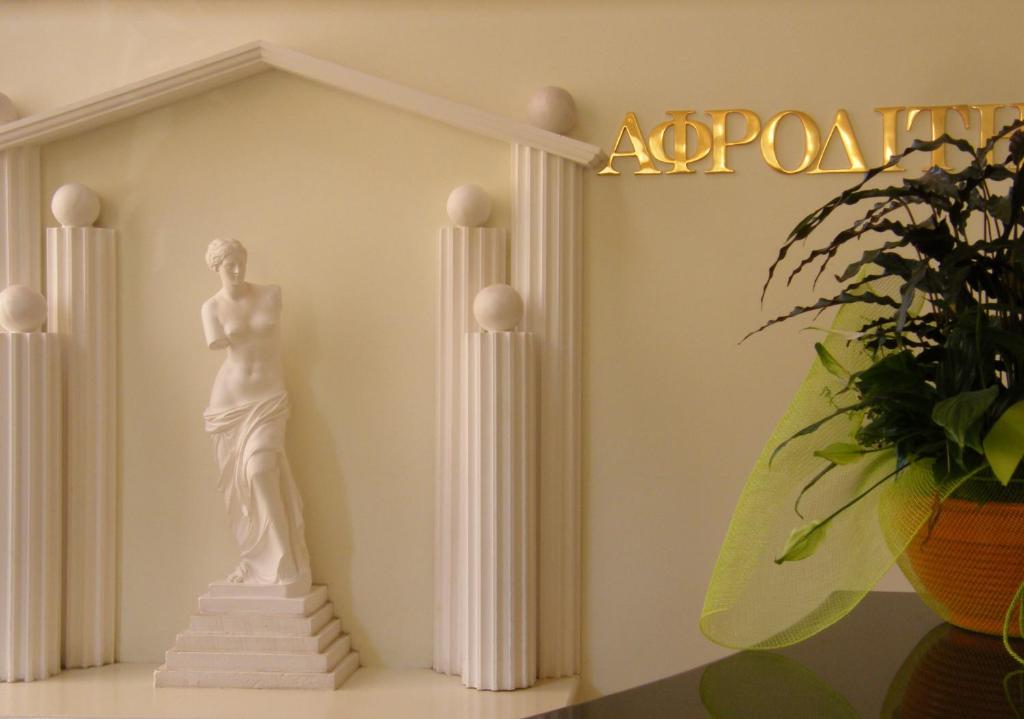 une statue d'un homme dans une pièce avec colonnes dans l'établissement Ξενοδοχείο Αφροδίτη- Hotel Aphrodite, à Naupacte