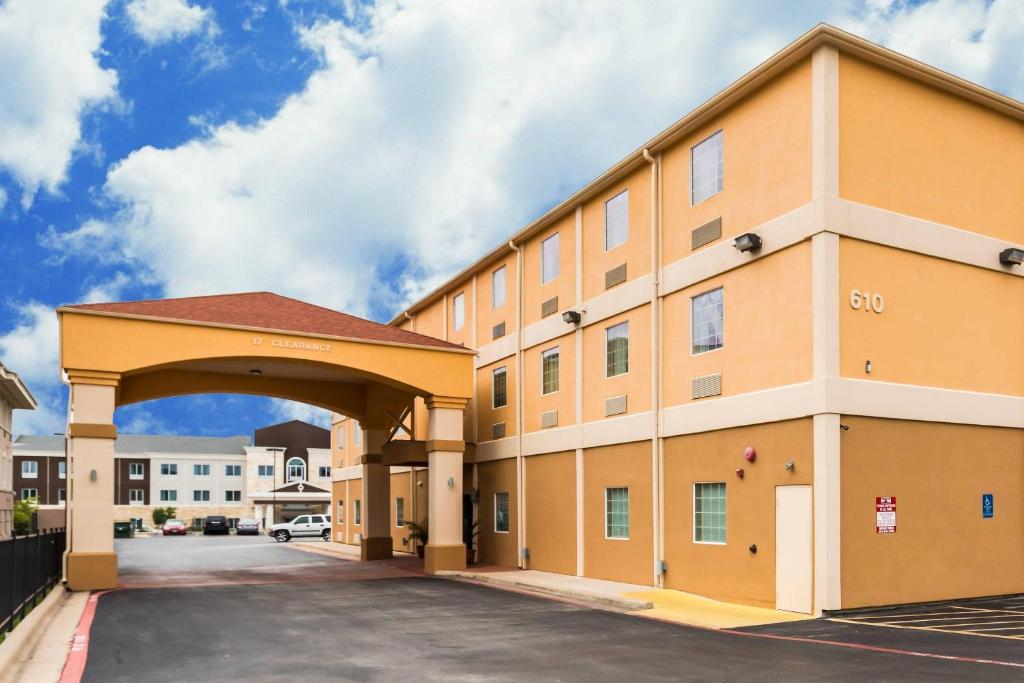 a large orange building with an archway in a parking lot at Quality Inn Killeen Near Fort Hood in Killeen