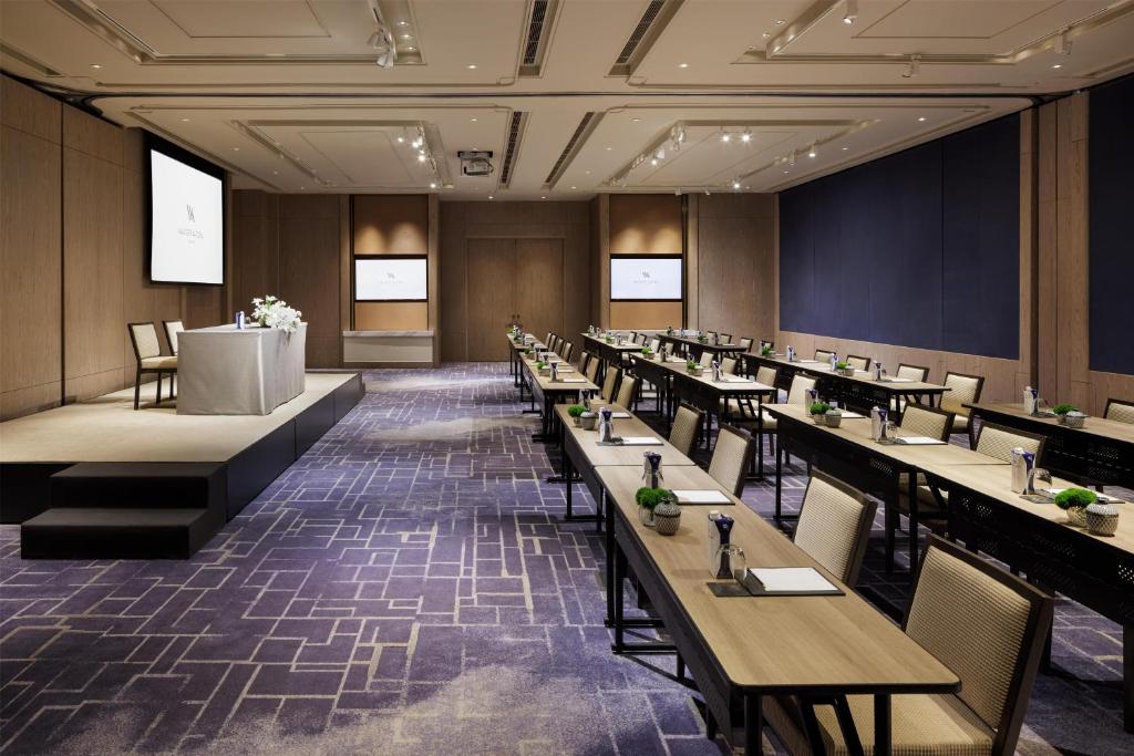 A conference hall arranged in classroom style beside a raised presentation stage.