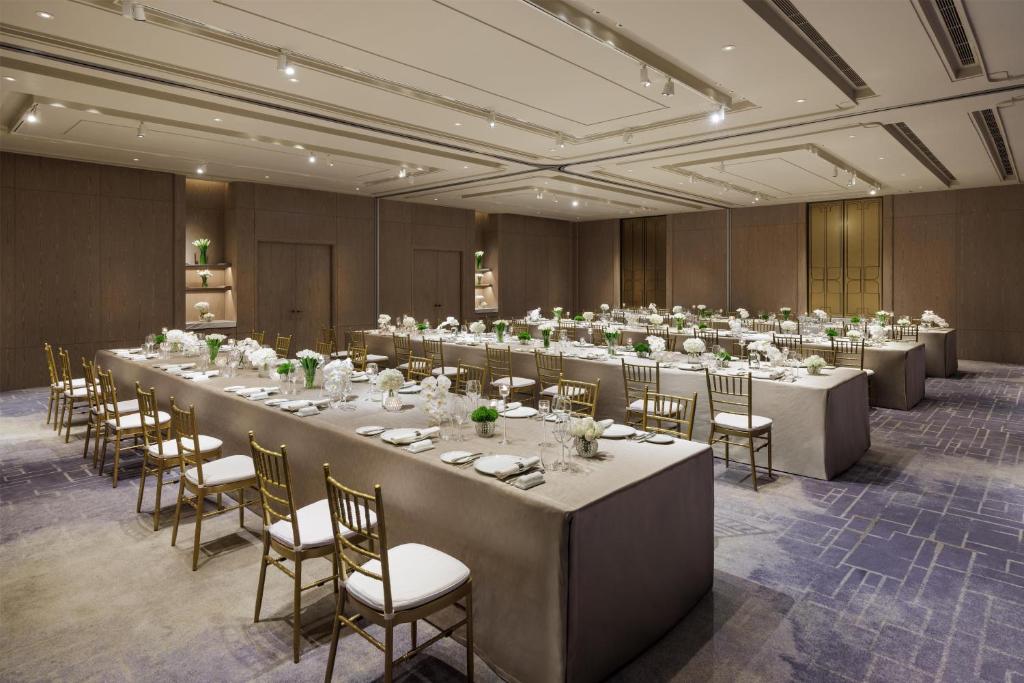 A formally set banquet room with long rectangular tables.