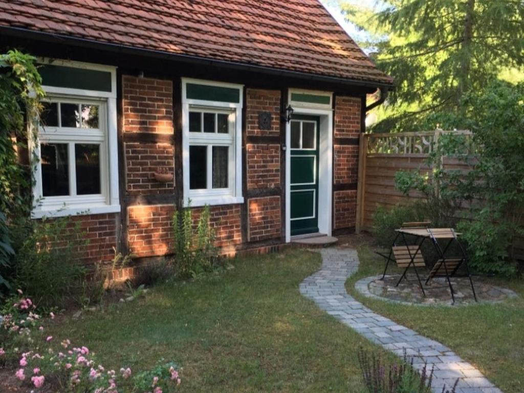 a brick house with a table in the yard at Alte Schule Nausdorf in Lenzen