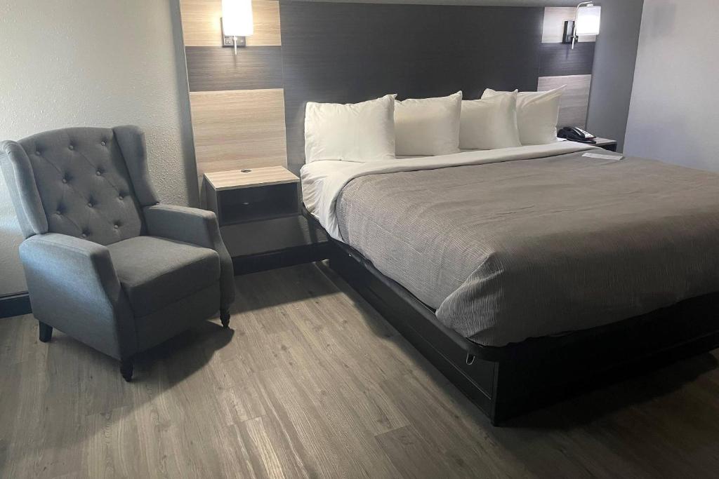 a bed and a chair in a hotel room at Quality Suites Abilene Mall Area in Abilene