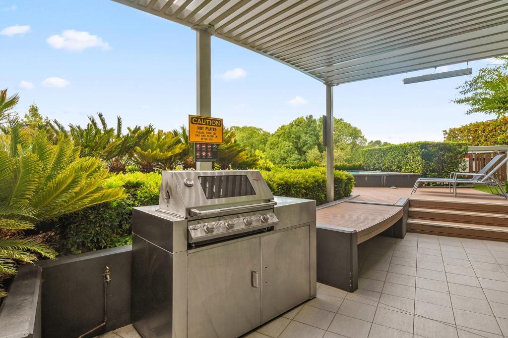 an outdoor kitchen with a grill on a patio at Stylish 1-Bed in CBD with Secure Underground Parking in Canberra