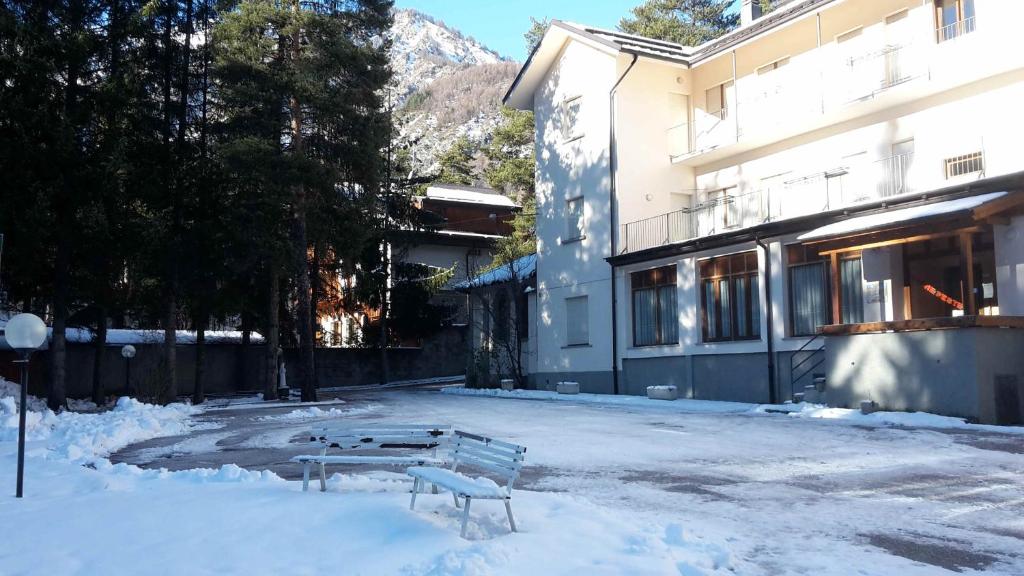 a bench in the snow in front of a building at Casa San Francesco in Bardonecchia