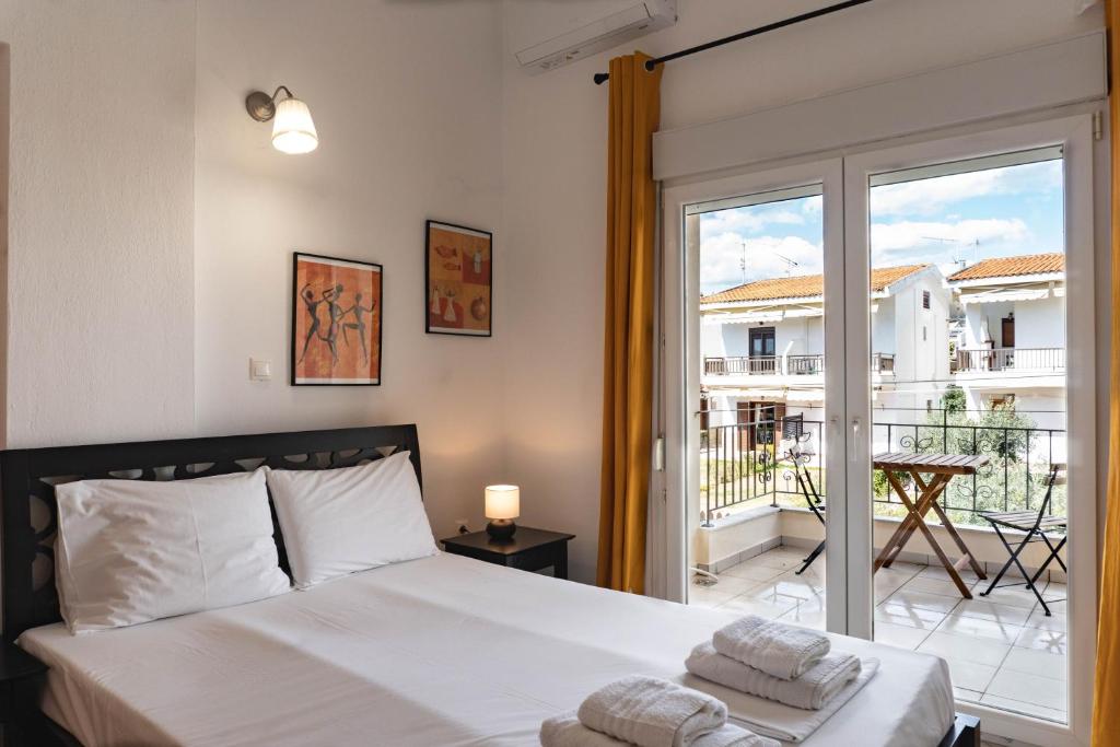 a bedroom with a bed and a large window at Apollo Sea Side Maisonette, Nikiti in Nikiti