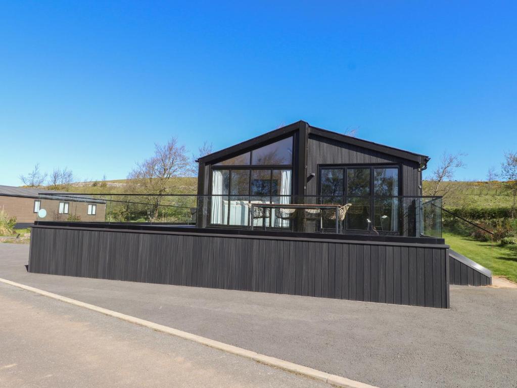 a black house with a table on the roof at Encil Gyfrinfa in Pwllheli