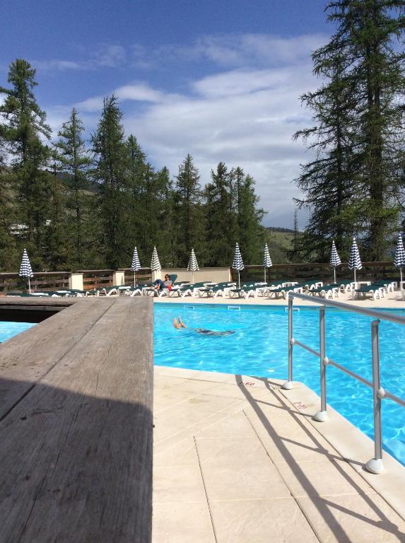 ein Pool mit einer Person, die im Wasser schwimmt in der Unterkunft Appartement Résidence Albane Vars in Vars