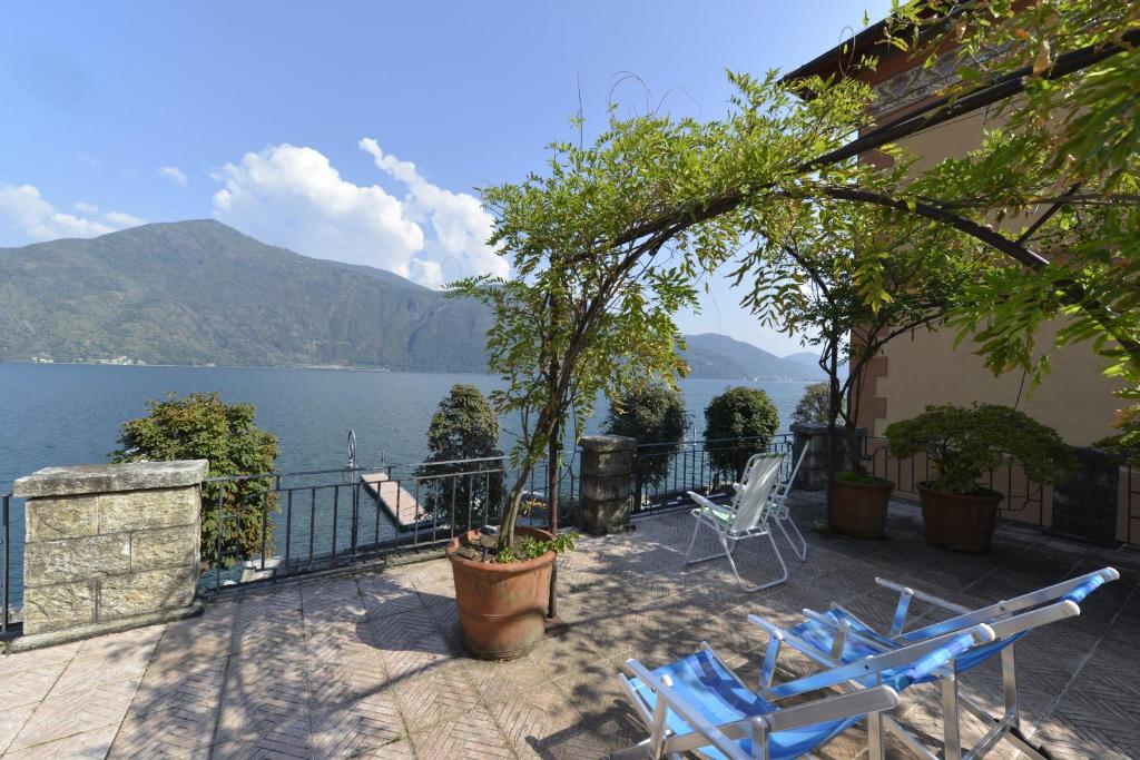 a patio with chairs and a view of a lake at Casa la Terrazza sul Lago - WelcHome in Cannobio