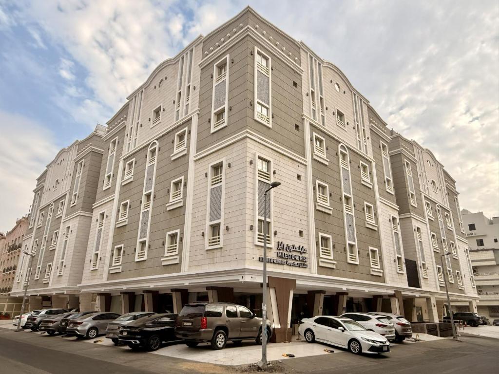 a large building with cars parked in front of it at Milestone Rise Jeddah in Jeddah