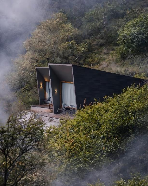 a black house on a hill in the forest at ARTOTEL Cabin Bromo in Bromo