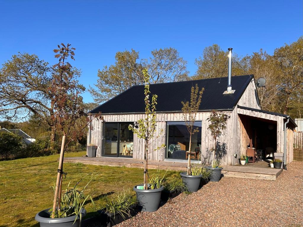 a small shed with potted plants in front of it at An Airigh, overlooking Loch Fyne in Cairndow