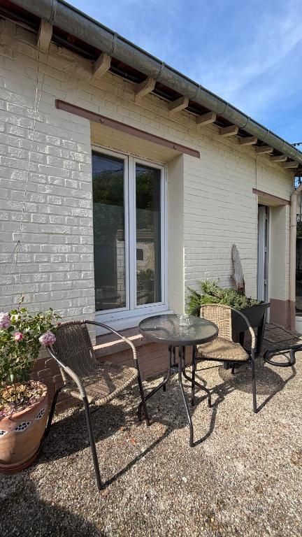 a patio with a table and chairs in front of a house at Mini studio et espace extérieur in Méry-sur-Oise