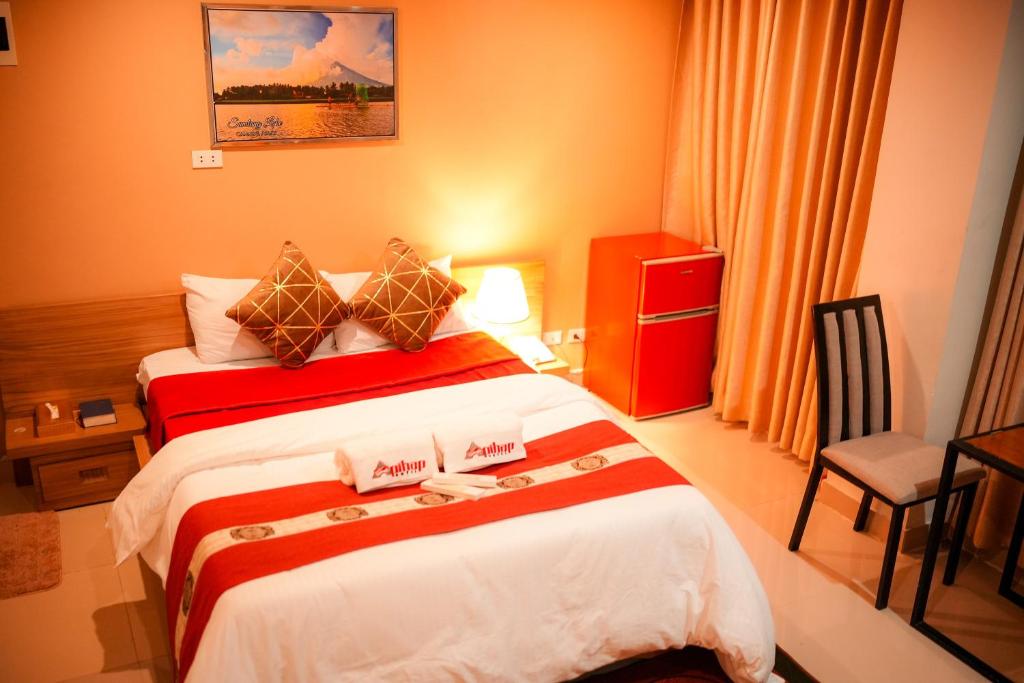 a hotel room with two beds and a chair at Apihap Hotel Daraga Albay in Locsin
