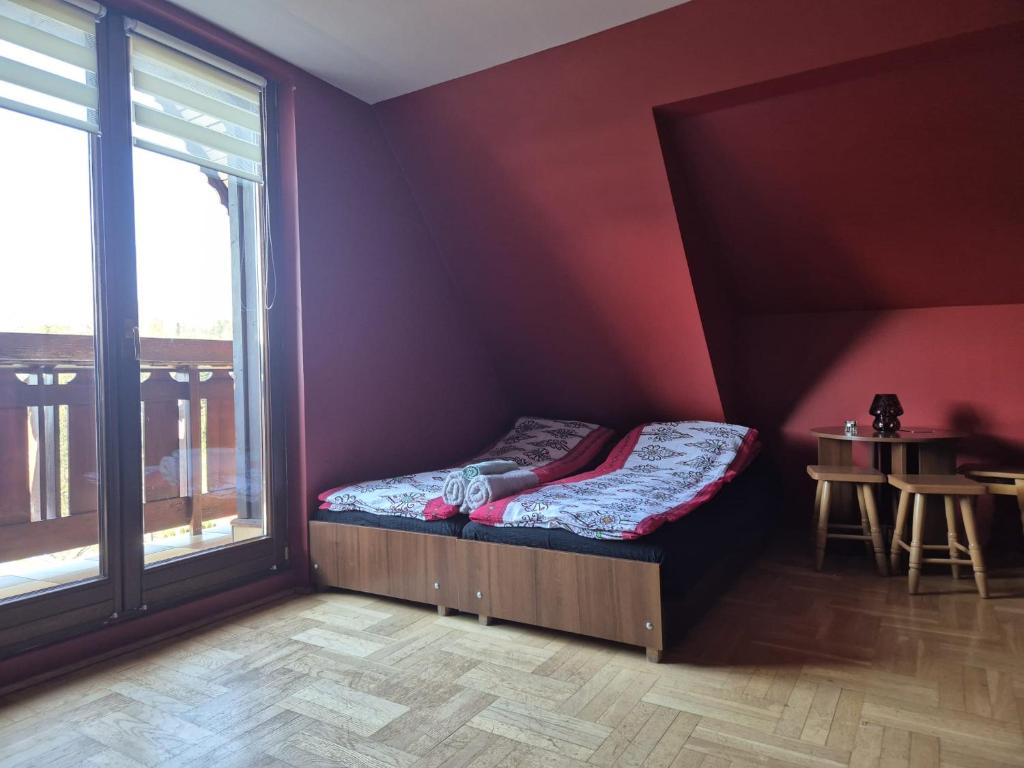 a bedroom with a bed and a table and a window at Endurance in Krośnica