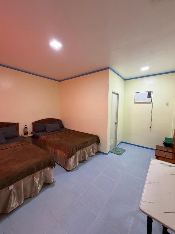 a room with two beds and a table in it at Anda Seabreeze Pension Haus in Anda