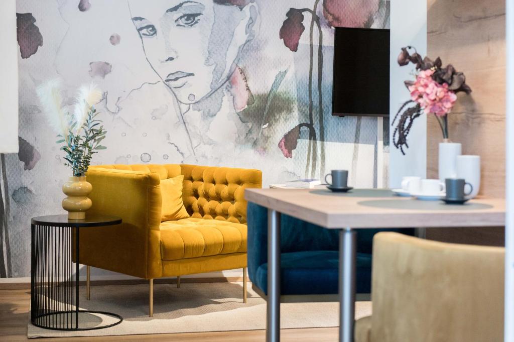 a living room with a yellow couch and a table at CHICLIVING Appartements in St. Wolfgang