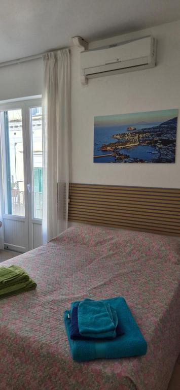 a bed with a blue towel on top of it at Casa Giusto Ischia 3 in Ischia Town