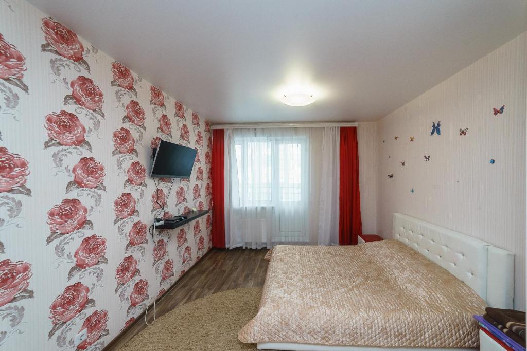 ケメロヴォにあるApartment on Pritomskiy prospektのベッドルーム1室(壁にバラのベッド1台付)