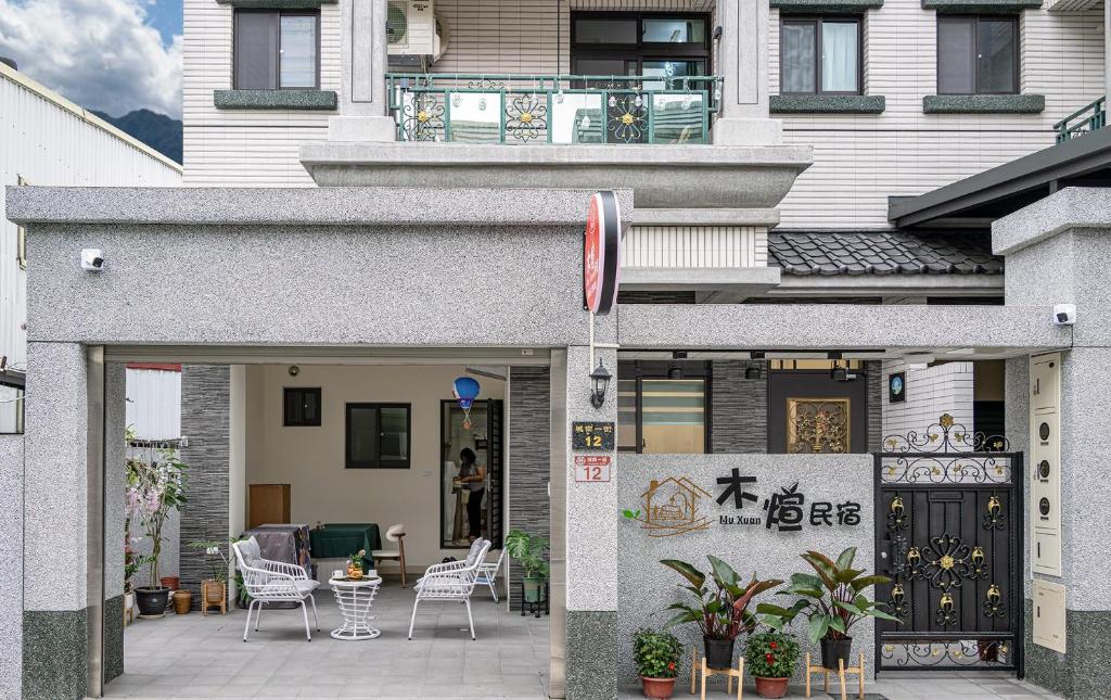 a building with a patio with chairs and a table at Muxuan Homestay in Yuli
