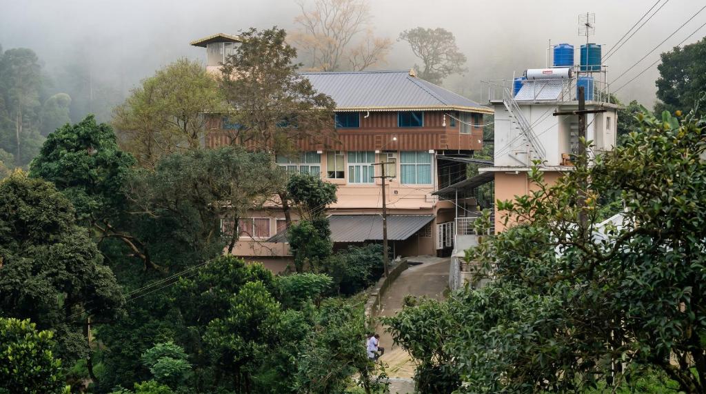 a house on the side of a hill with trees at SPKA Jungle Resort in Vālpārai