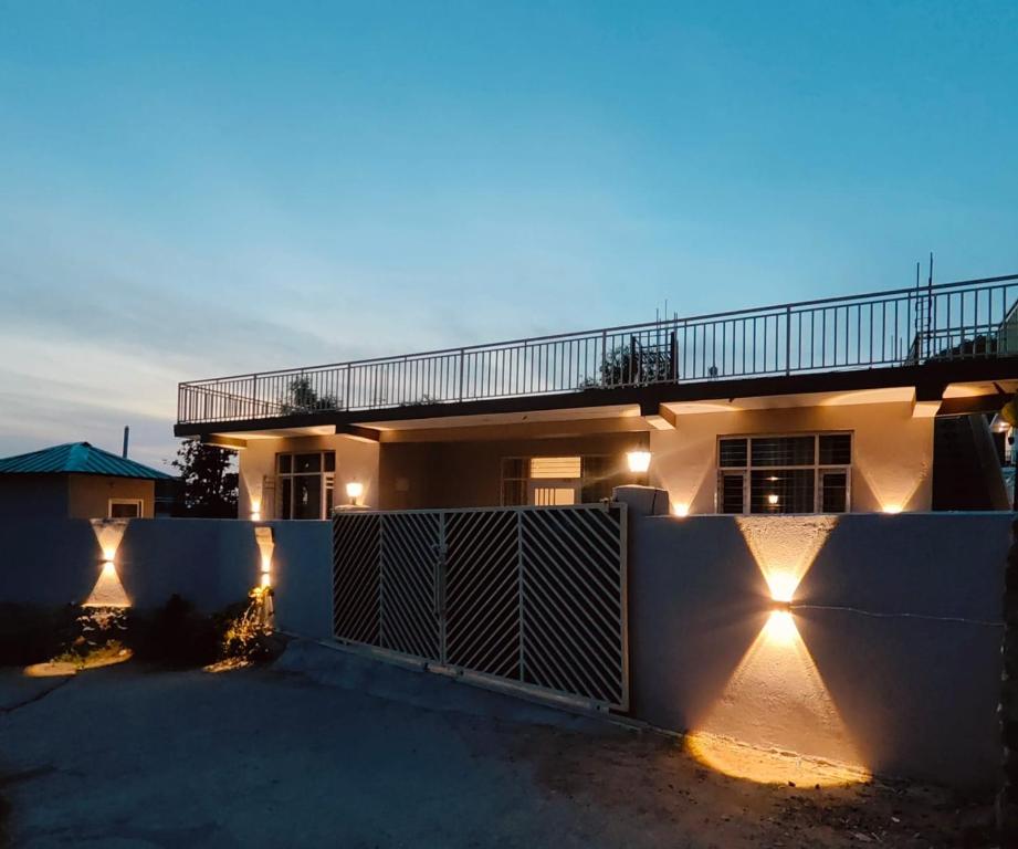 ein Haus mit einem Zaun, der mit Lichtern beleuchtet ist in der Unterkunft CloudHaus Bir Private 3BHK Villa Mountain Views in Bir