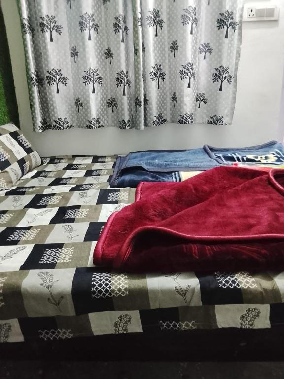 a bed with a blanket on it with a curtain at Dev Giri Guest House in Phata