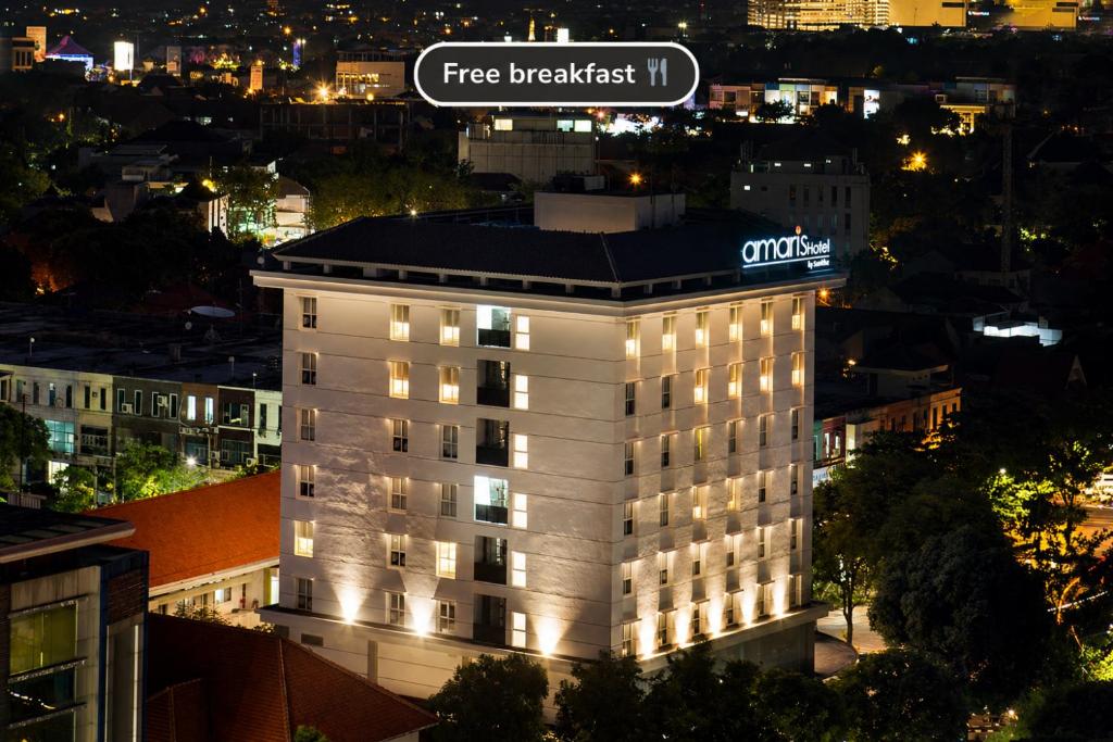 a hotel building with a sign on top of it at Amaris Hotel Darmo Surabaya in Surabaya