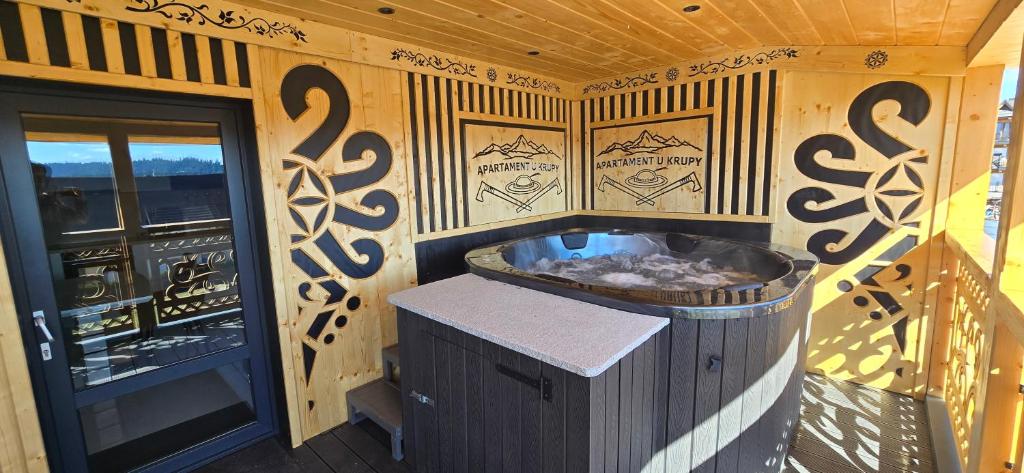 a wooden cabin with a hot tub in a room at Apartament u Krupy z Prywatnym Jacuzzi i tarasem Widokowym in Murzasichle