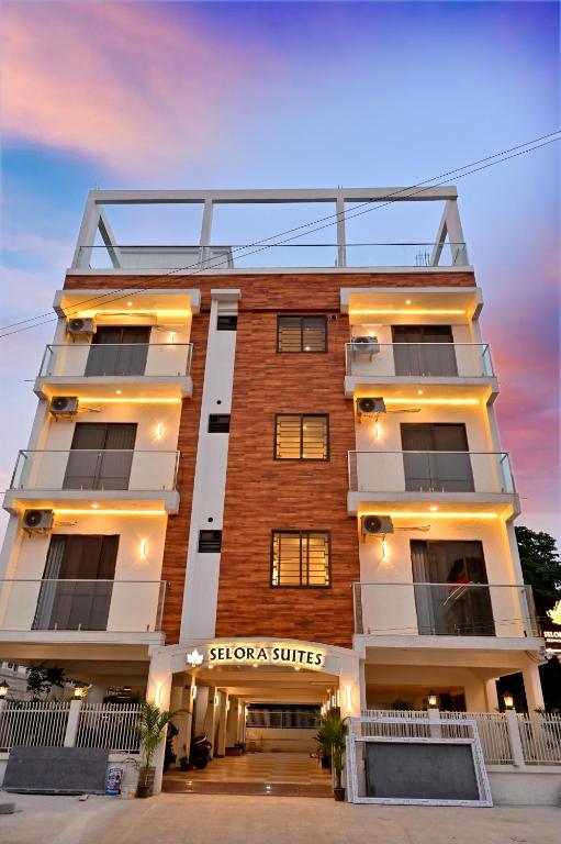 a tall building with a sign on the front of it at Selora Suites Serviced Apartments in Mysore
