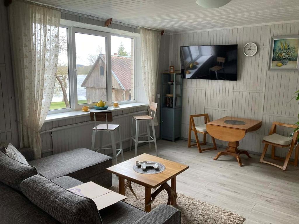 a living room with a couch and a table at Našio Kempingo Apartamentai in Antanaše