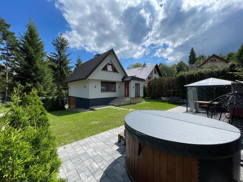 a backyard with a house and a table in the yard at Chata Rosa in Námestovo