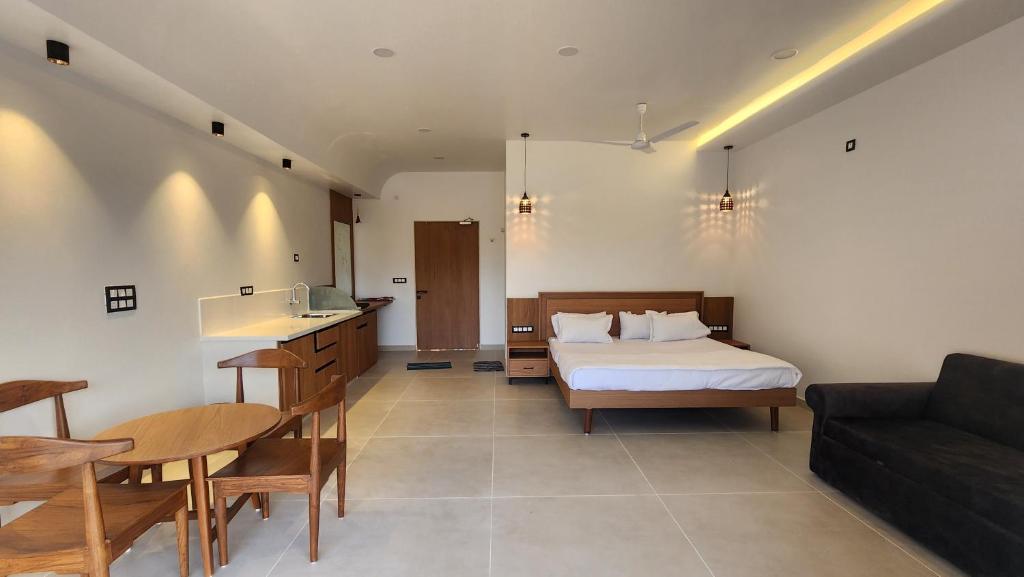 a bedroom with a bed and a table and a couch at Amrutiya Farm in Bhuj