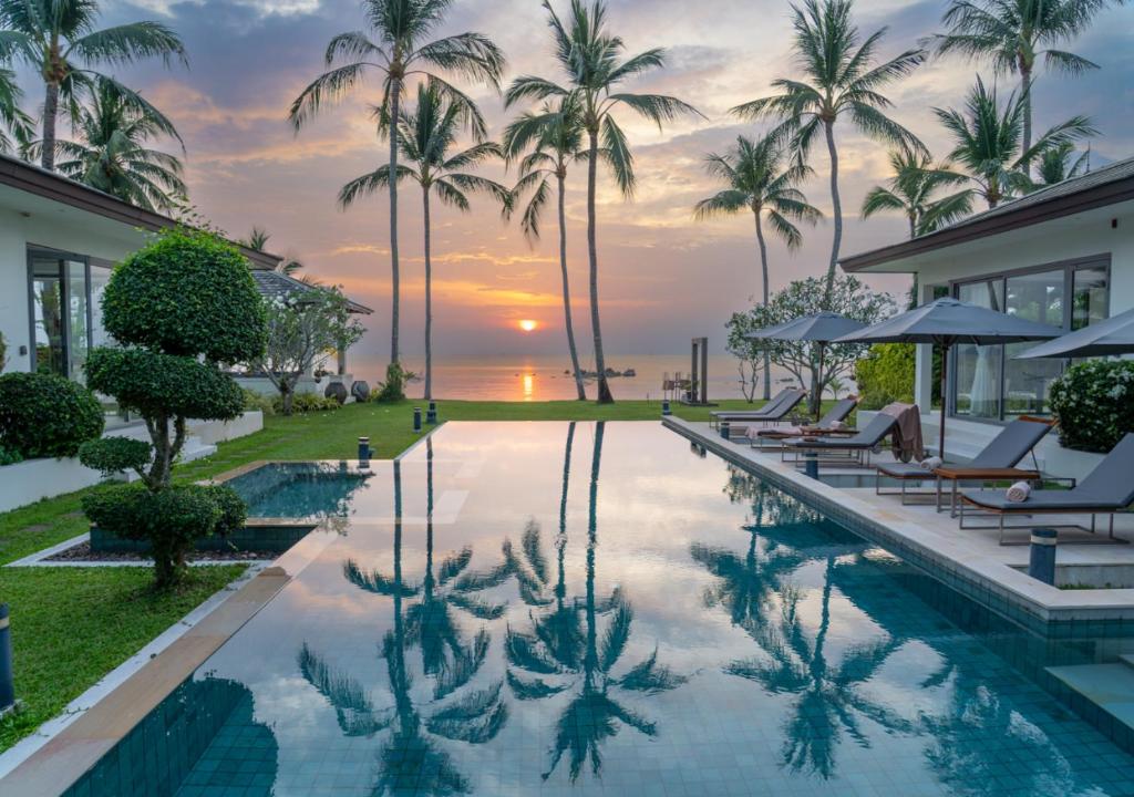 a pool at the resort with palm trees at Baan Asan in Taling Ngam Beach