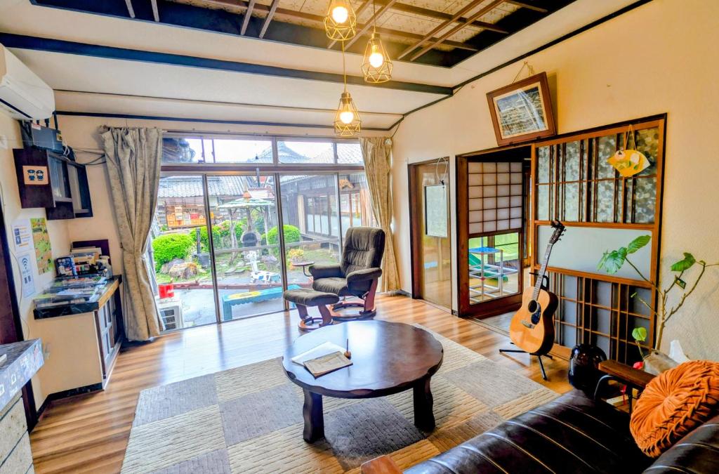 a living room with a couch and a table and a guitar at Kominka engawa in Kakamigahara