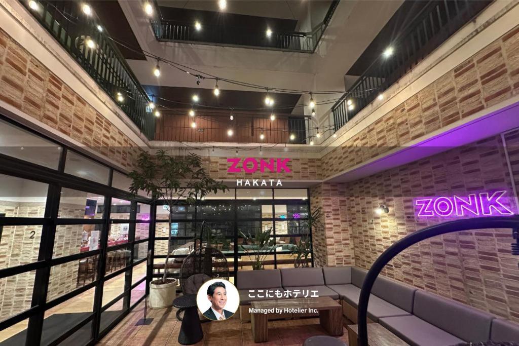 a person sitting in the lobby of a building at ZONK HOTEL Hakata in Fukuoka
