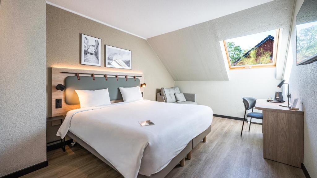a hotel room with a large bed and a desk at Campanile NATURE - Aix Les Bains in Aix-les-Bains