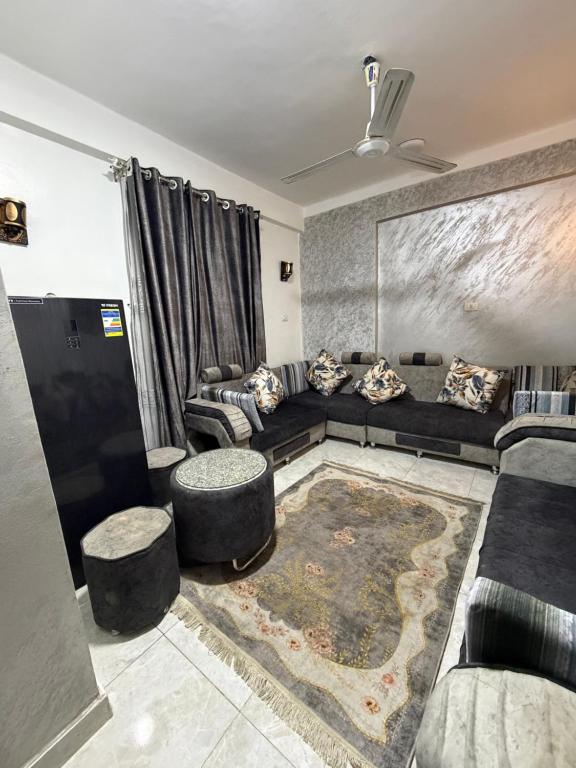 a living room with a couch and two stools at Center Apartment in Aswan